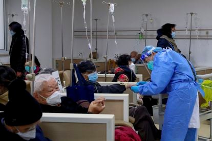 Un sanitario ayudaba el día 5 a un paciente con el goteo intravenoso en una institución de salud comunitaria en Shanghái.