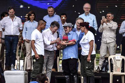Una pareja de guerrilleros entrega a su bebé a Rodrigo Londoño, líder de las FARC, y al presidente colombiano Juan Manuel Santos, durante el acto del final de las armas en Mesetas (Colombia).