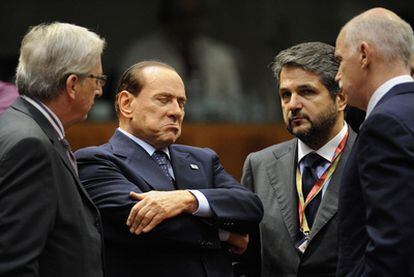 Jean Claude Juncker, a la izquierda, conversa con Berlusconi y Papandreu en Bruselas en presencia de un traductor.