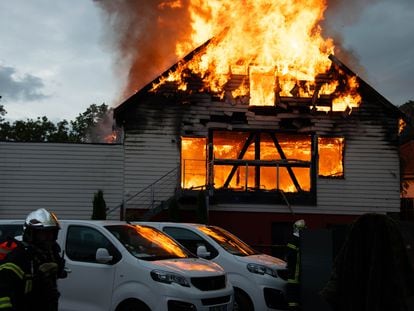 Unos bomberos intentan extinguir el fuego en la residencia de verano, este miércoles en Wintzenheim (Francia).