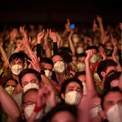 People take part in a music concert in Barcelona, Spain, Saturday, March 27, 2021. Five thousand music lovers are set to attend a rock concert in Barcelona on Saturday after passing a same-day COVID-19 screening to test its effectiveness in preventing outbreaks of the virus at large cultural events. The show by Spanish rock group Love of Lesbian has the special permission of Spanish health authorities. While the rest of the country is limited to gatherings of no more than four people in closed spaces, the concertgoers will be able to mix freely while wearing face masks. (AP Photo/Emilio Morenatti)