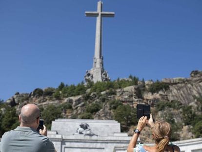 Dos visitantes hacen fotos en el Valle de los Caídos. En vídeo, Los Franco tachan de "ilegal" el traslado de Franco a El Pardo.