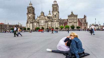 Dos turistas sentados en la plaza dell Zócalo, desde donde se observa el hundimiento de la Catedral Metropolitana.