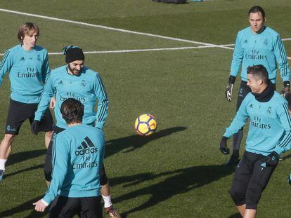 Benzema, con gorro, bromea con Cristiano en un rondo en el entrenamiento de este viernes. 