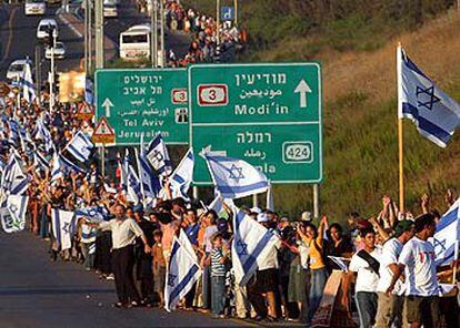 Centenares de ciudadanos israelíes forman la cadena humana a su paso por el enlace de carreteras de Latrun, en el centro de Israel.