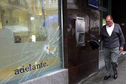 Un vecino pasa ante una oficina bancaria de Algorta que fue atacada por radicales el 31 de julio.