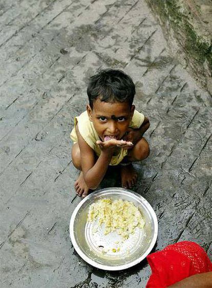 Un niño come en una infravivienda de Calcuta (India) el 16 de octubre de 2006, víspera del Día Internacional para la Erradicación de la Pobreza.