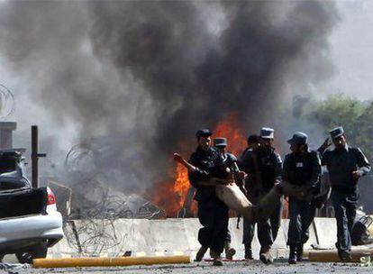 Policías afganos transportan a uno de los heridos en un atentado con coche bomba ante la base de la OTAN en el aeropuerto de Kabul.