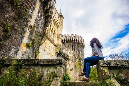 Una joven contempla el castillo vizcaíno de Butrón.