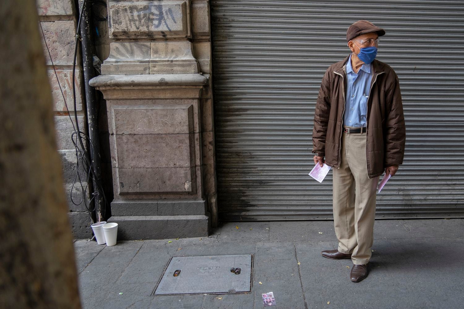 Gerardo Zamora, de 68 años, reparte información de una óptica en el centro de la Ciudad de México con una mascarilla durante la crisis del coronavirus.