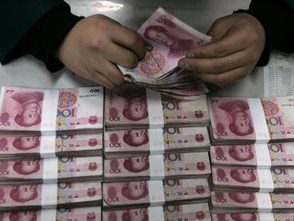 Un empleado del Bank of China cuenta billetes de 100 yuanes en Taiyuan, provincia de Shanxi.