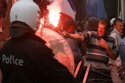 Un policía antidisturbios controla a los pescadores durante una protesta realizada en Bruselas para exigir a la Comisión Europea medidas contra el alza del gasóleo.