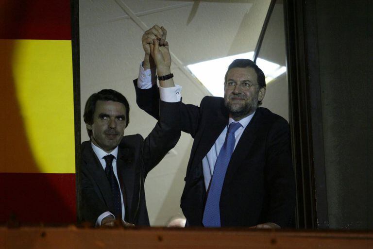 José María Aznar y Mariano Rajoy saludan a los partidarios del PP desde la ventana de la sede del partido en Madrid, tras el resultado de las elecciones generales del 14 de marzo de 2000.