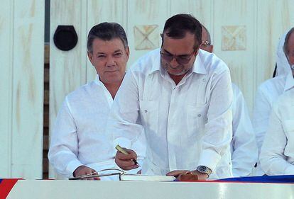 El máximo líder de las Fuerzas Armadas Revolucionarias de Colombia (FARC), Rodrigo Londoño Echeverri, alias 'Timochenko', firma el acuerdo de paz frente al presidente de Colombia, Juan Manuel Santos (i), en la ceremonia de la firma del acuerdo de paz en la ciudad de Cartagena (Colombia). 