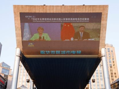 La alta comisionada de la ONU, Michelle Bachelet, y el presidente chino Xi Jinping durante un encuentro virtual televisado en un centro comercial de Pekín.