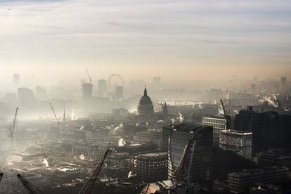 La catedral de San Pablo de Londres, en el centro, y el London Eye, al fondo, entre la polución y la niebla. |