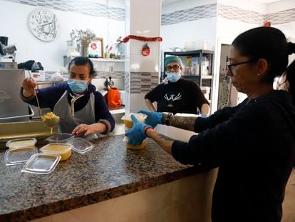 Voluntarios reparten alimentos en el día de Nochebuena, en Málaga.