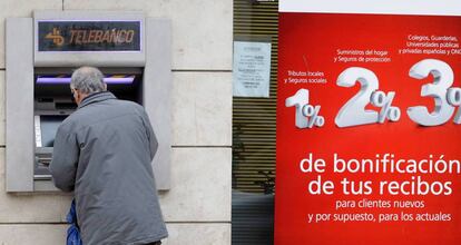 Un cliente bancario saca dinero de un cajero automático en Madrid, en una imagen de archivo.