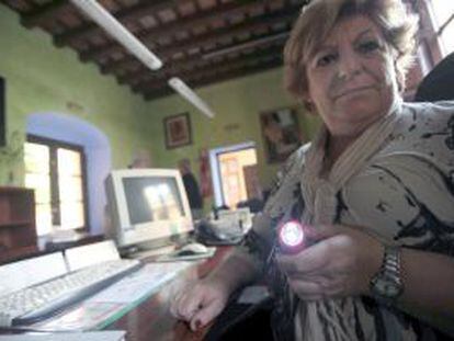Una trabajadora de la Casa de la Cultura de los Barrios (Cádiz) usa linterna tras haberle cortado la luz por falta del pago del Ayuntamiento.