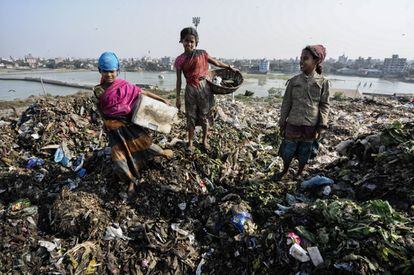 Tres niñas menores de edad recogen plásticos u ortos objetos de 'valor' en un vertedero de Dacca.
