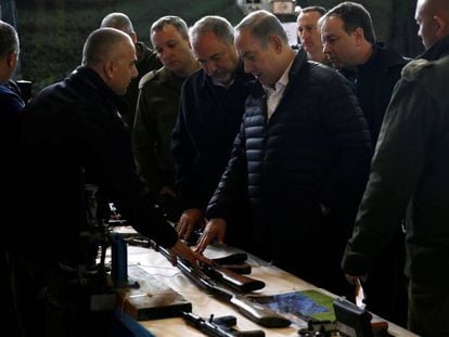 El primer ministro israel&iacute;, Benjam&iacute;n Netanyahu (c), observa una muestra de armas confiscadas en Cisjordania, este martes. 