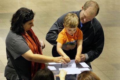 Un nen diposita el vot dels seus pares al Casinet d'Hostafrancs.