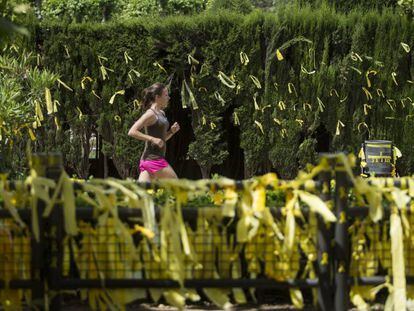 Una joven corre en una zona repleta de lazos amarillos, en el parque de la Ciutadella.