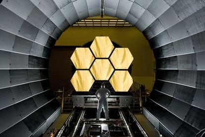 A NASA operator in front of six of the 18 pieces of the mirror of the future 'James Webb' space telescope.