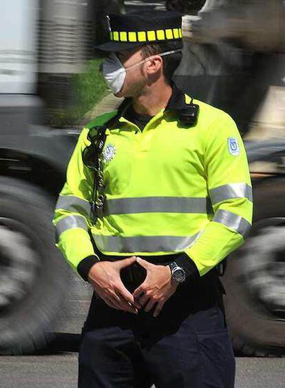 Un agente con mascarilla vigila el tráfico en la capital.