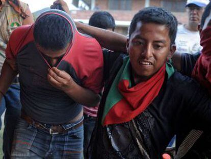 Un grupo de ind&iacute;genas lleva detenido a un supuesto miembro de las FARC al que capturaron en Bel&eacute;n, en el Cauca, el mi&eacute;rcoles.