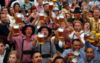 Un grupo de asistentes levantan sus jarras de cerveza durante la inauguración del Oktoberfest en Múnich, el 20 de septiembre de 2014.