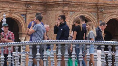 Un turista fuma en la Plaza de España de Sevilla.