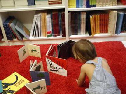 Un nen juga amb llibres infantils en una llibreria.