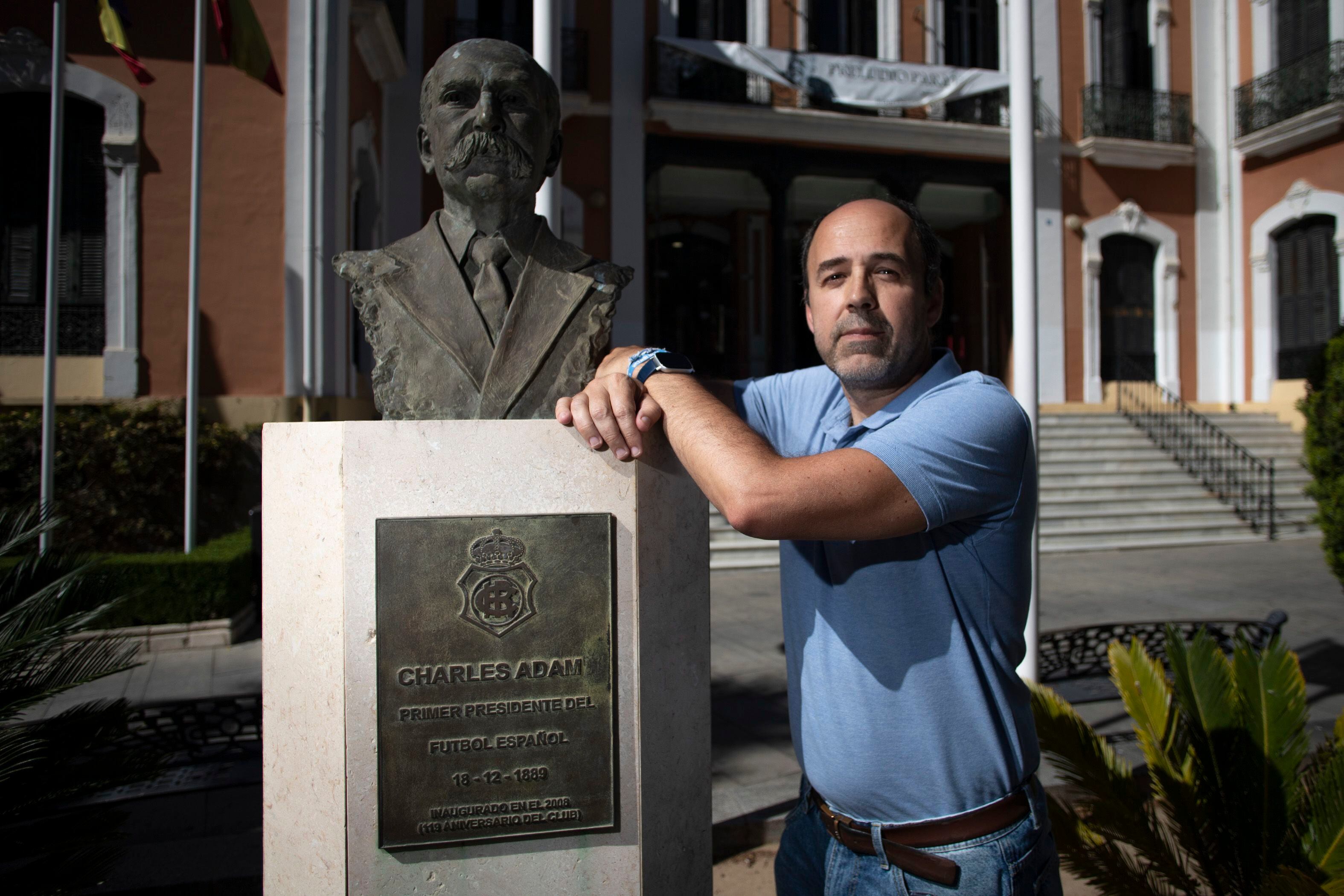Alejandro López, uno de los promotores del Recre Trust junto al busto de Charles Adam, primer presidente del fútbol español.