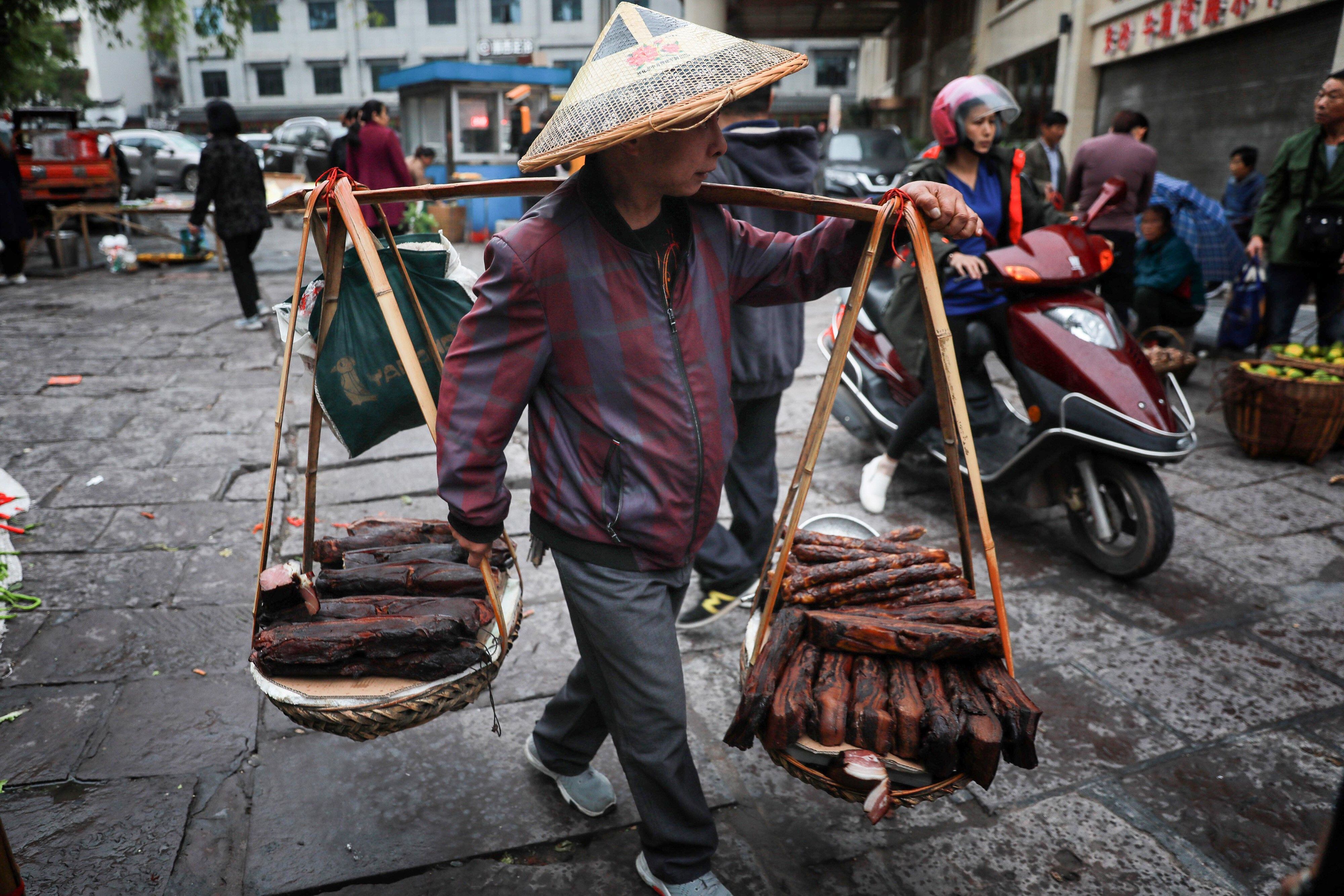 Un vendedor ambulante trabaja en la ciudad antigua de Fenghuang en Xiangxi, China central.