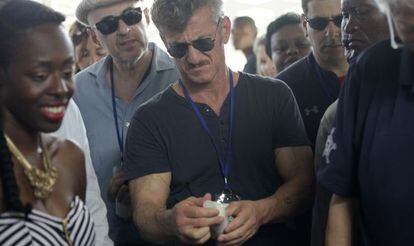 El actor Sean Penn revisa una botella de aceite de ricino en Haití.