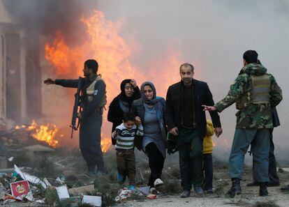 Un grupo de supervivientes se abre paso en el lugar de un atentado ocurrido en Kabul (Afganistán).