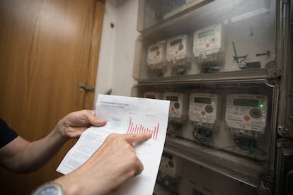 Un usuario muestra su factura junto al contador de luz de su vivienda en Madrid, en una foto de archivo.