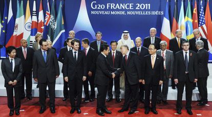 Sarkozy saluda a Ángel Gurría, presidente de la OCDE, en la foto de autoridades financieras y económicas.