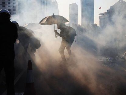 Un manifestante se protege con un paraguas de los gases lacrimógenos lanzados por la policía en Hong Kong.