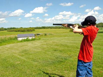 Un niño apuntando con una escopeta.
