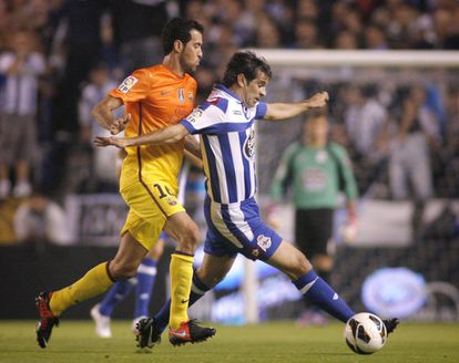 Valerón conduce ante la presión de Busquets.