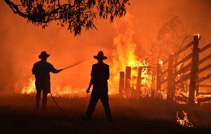 Dos personas residentes en una propiedad afectada por un incendio forestal en Hillsville, a 350 km al norte de Sydney.