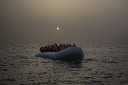 Varios refrugiados y migrantes esperan, a bordo de un un bote de goma a la deriva, a ser asistidos por miembros de la ONG española Proactiva Open Arms.