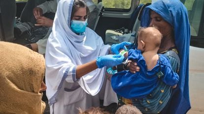 Akeela, orientadora de salud de Médicos Sin Fronteras, atiende a un bebé durante las inundaciones de Pakistán.