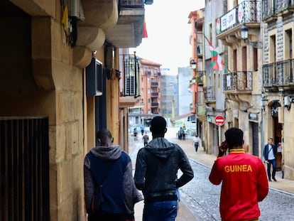 Tres jóvenes recorren el camino desde el albergue de la Cruz Roja de Irún hasta un punto de información para inmigrantes, en julio de 2021.