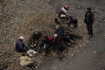 Un grupo de mineros descansan en la hora del almuerzo. Algunos consumen hoja de coca. Dicen que les ayuda para aguantar las jornadas extenuantes, el frío intenso, y los 4.000 metros de altura a los que trabajan.