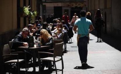 Un camarero sirve en una terraza de Madrid. 