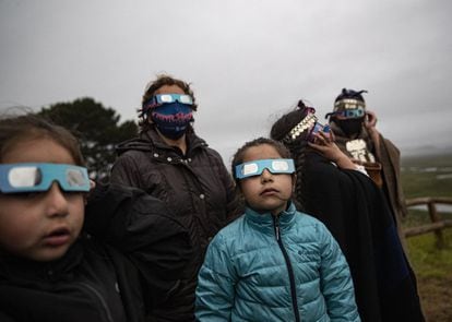 Una familia indígena mapuche usa lentes especiales durante un eclipse solar total en Carahue, Chile.
