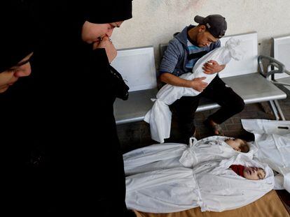Una familia palestina junto a los cuerpos de dos gemelas, Joid y Maria y su hijo Omar, muertos por un misil israelí en un hospital en Rafah, al sur de la Franja de Gaza, el 12 de diciembre.